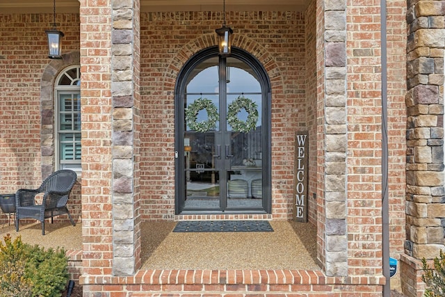 entrance to property featuring french doors and brick siding