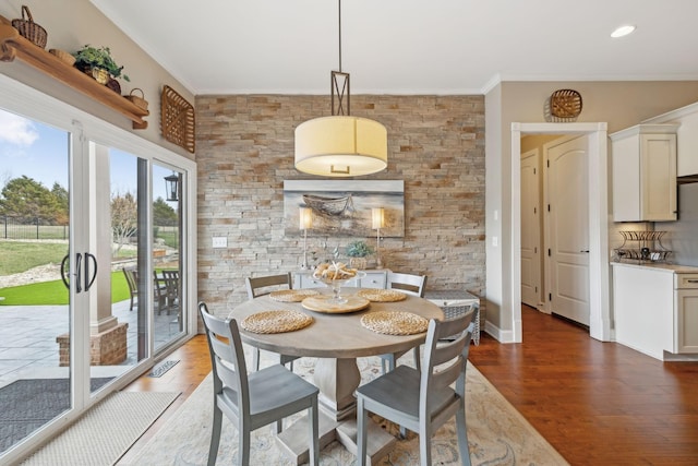 dining room featuring ornamental molding and dark wood finished floors