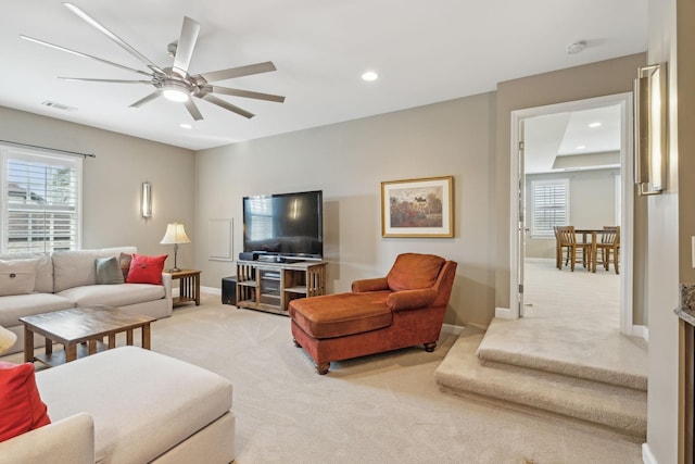 living area featuring light carpet, plenty of natural light, and visible vents