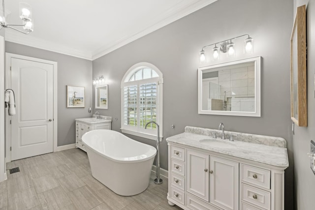 bathroom featuring a sink, a tile shower, crown molding, a freestanding tub, and two vanities