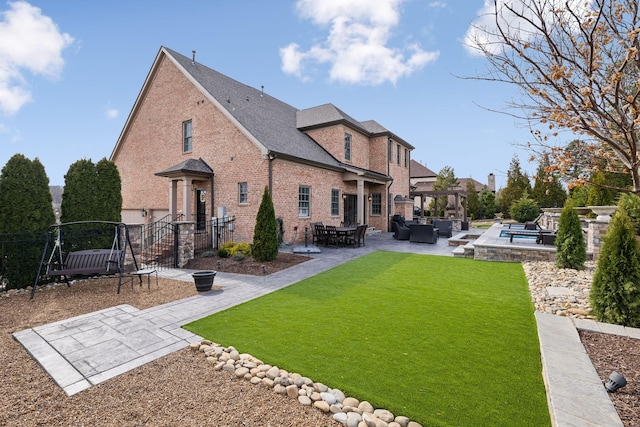 back of house featuring a patio, fence, a yard, an outdoor living space, and brick siding