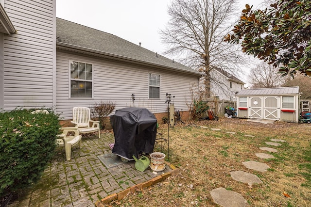 view of yard with a storage shed, a patio area, fence, and an outdoor structure