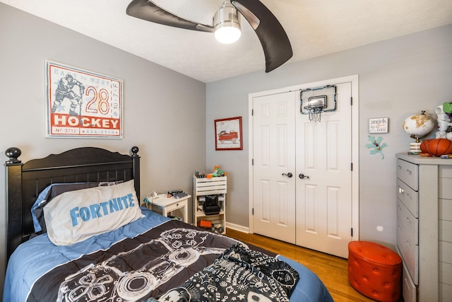 bedroom with a closet, ceiling fan, and wood finished floors