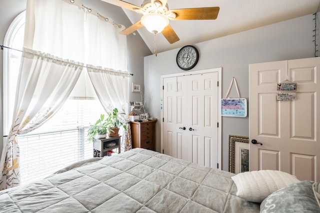 bedroom with ceiling fan, vaulted ceiling, and a closet