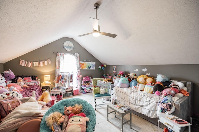 playroom with lofted ceiling, a textured ceiling, carpet flooring, and a ceiling fan