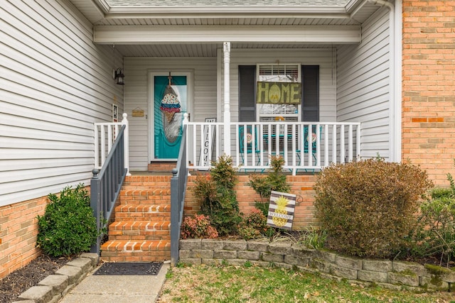 doorway to property featuring a shingled roof and brick siding