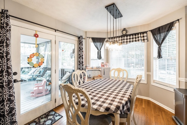 dining area featuring wood-type flooring, a wealth of natural light, and baseboards