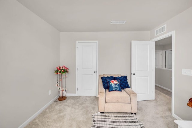 living area with carpet, visible vents, and baseboards