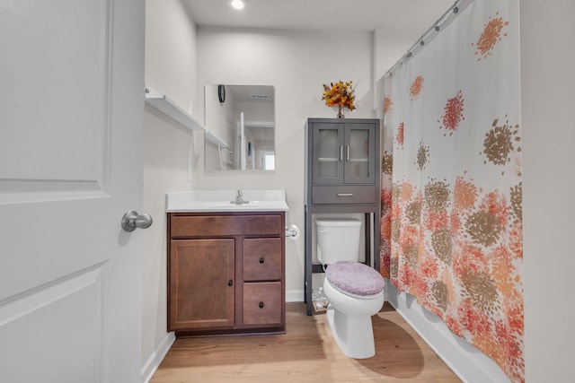 full bathroom featuring baseboards, vanity, toilet, and wood finished floors