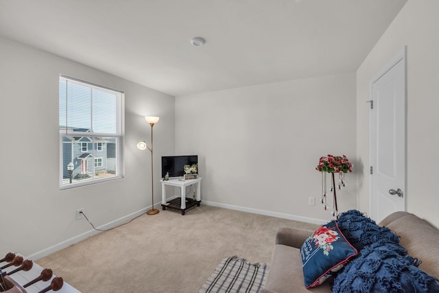 living area featuring carpet and baseboards