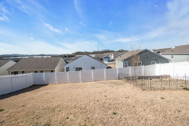 view of yard with a fenced backyard and a residential view