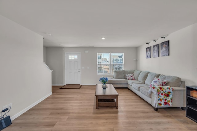 living area featuring light wood-style floors, visible vents, and baseboards