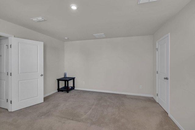 carpeted spare room featuring visible vents and baseboards