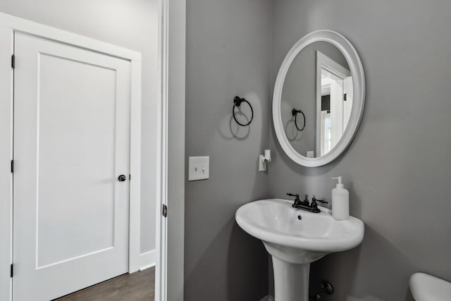 half bathroom featuring toilet and wood finished floors