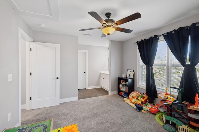 rec room with ceiling fan, visible vents, dark colored carpet, and baseboards