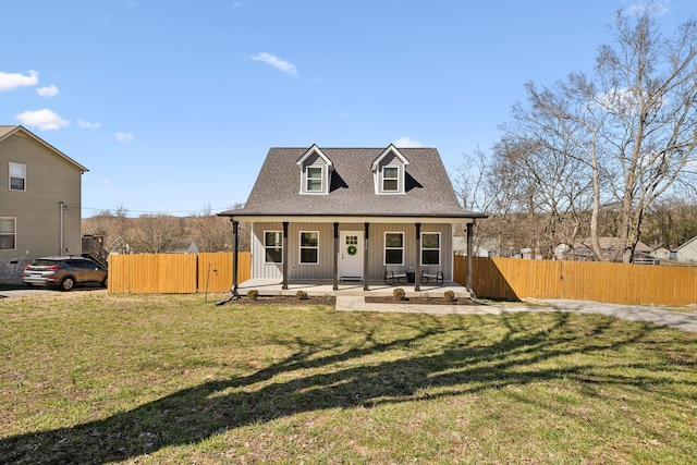 view of front facade featuring a porch, roof with shingles, a front lawn, and fence