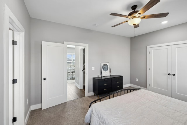 bedroom with connected bathroom, baseboards, carpet flooring, a closet, and a ceiling fan