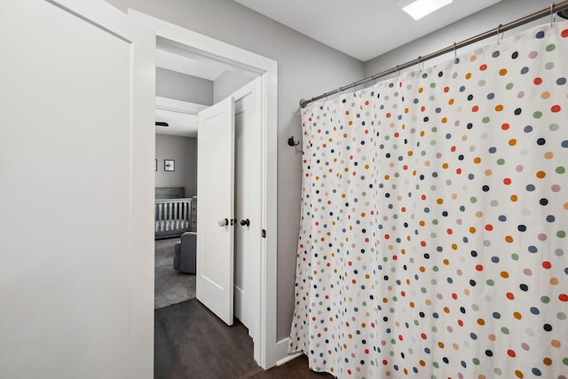 full bathroom featuring a shower with curtain and wood finished floors