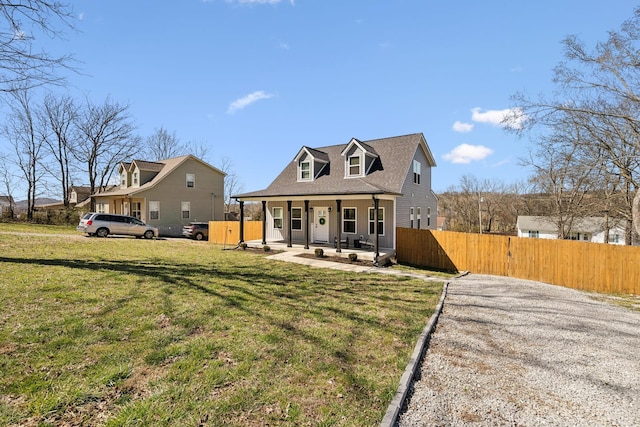 cape cod house with a porch, fence, and a front lawn