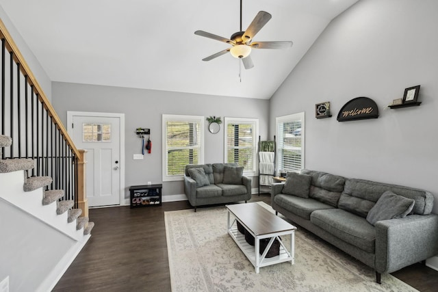 living room featuring wood finished floors, baseboards, high vaulted ceiling, ceiling fan, and stairs