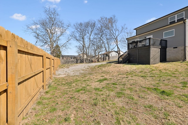 view of yard featuring stairs, a deck, and fence private yard