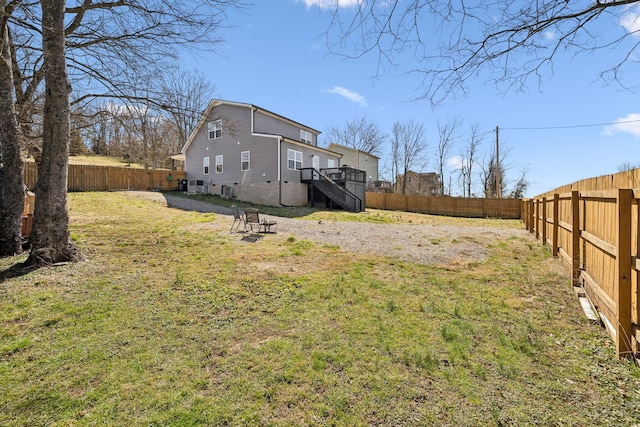 view of yard featuring a fenced backyard and stairs