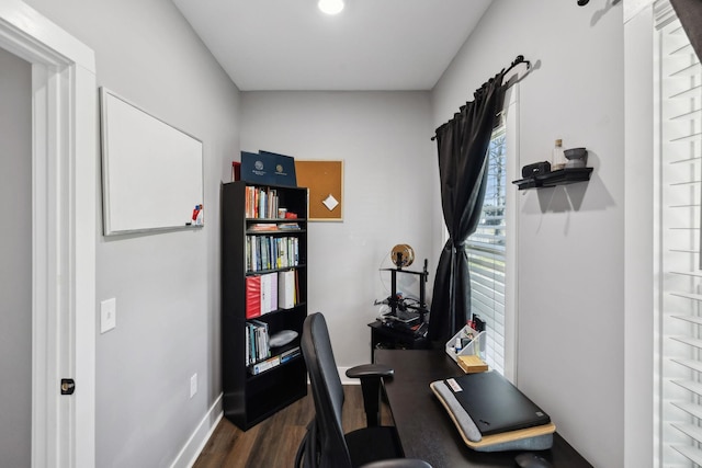 workout room featuring baseboards and dark wood-type flooring