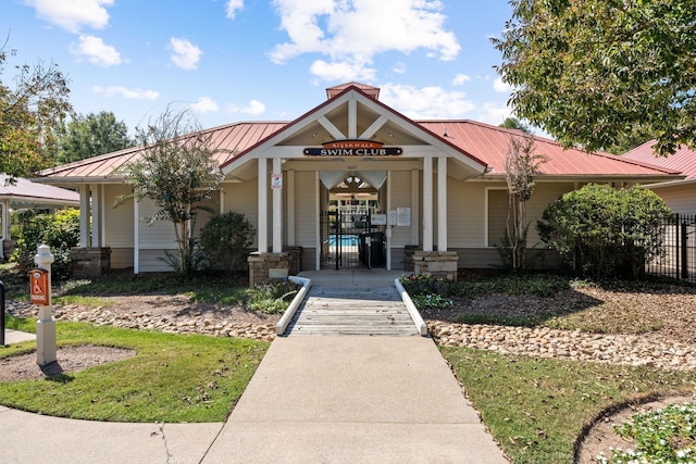 view of front of house featuring a gate, fence, and metal roof