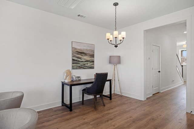 office featuring an inviting chandelier, baseboards, visible vents, and wood finished floors