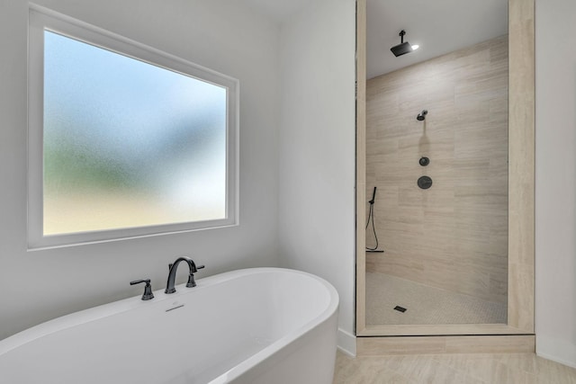 full bathroom featuring a soaking tub and a tile shower