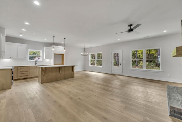 kitchen featuring light wood-style flooring, open floor plan, backsplash, and a center island