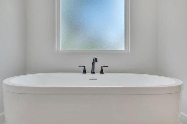 bathroom featuring a freestanding bath and plenty of natural light