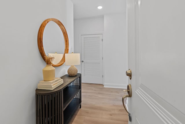 corridor with light wood finished floors, baseboards, and recessed lighting