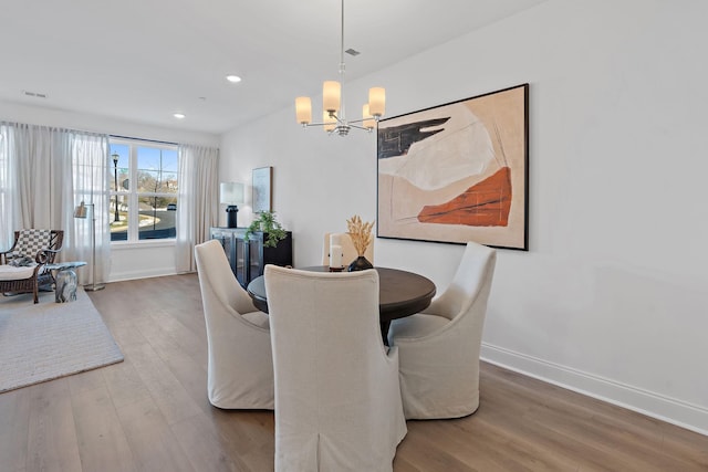 dining room featuring a chandelier, recessed lighting, baseboards, and wood finished floors