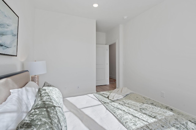 bedroom with recessed lighting, baseboards, and wood finished floors