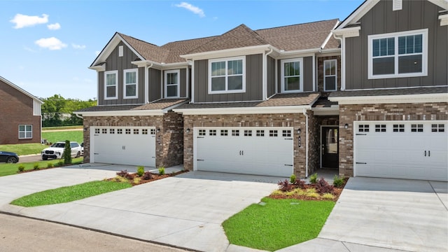 view of front of home featuring concrete driveway, brick siding, and board and batten siding