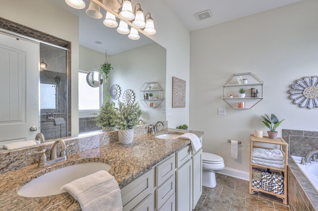 bathroom featuring double vanity, visible vents, toilet, and a sink