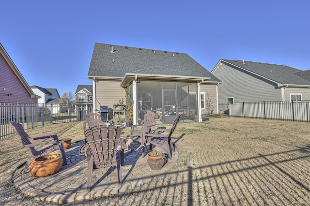 rear view of house with a patio, roof with shingles, a fenced backyard, and a sunroom