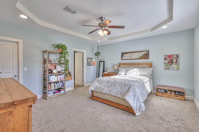 carpeted bedroom featuring visible vents, recessed lighting, a raised ceiling, and baseboards