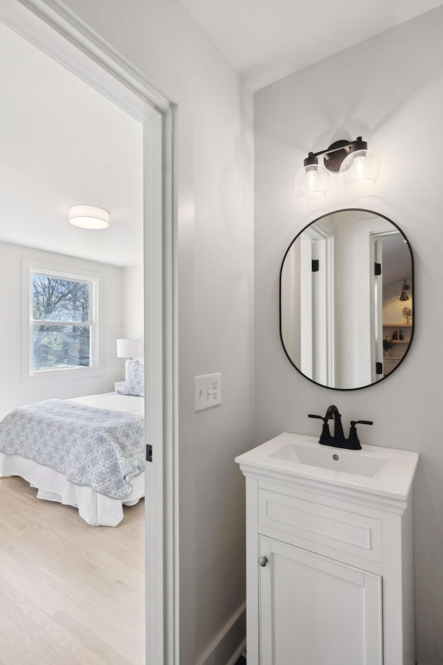 ensuite bathroom featuring wood finished floors, connected bathroom, and vanity