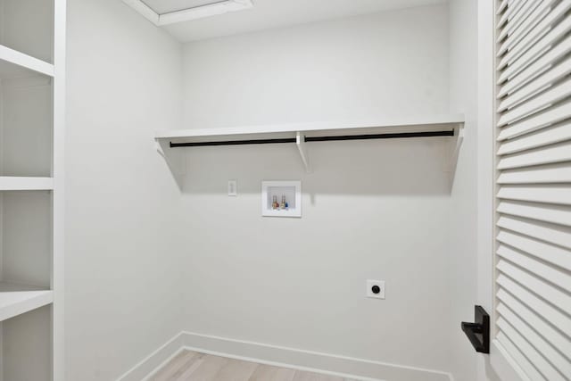 laundry area featuring laundry area, baseboards, hookup for a washing machine, light wood-style floors, and electric dryer hookup