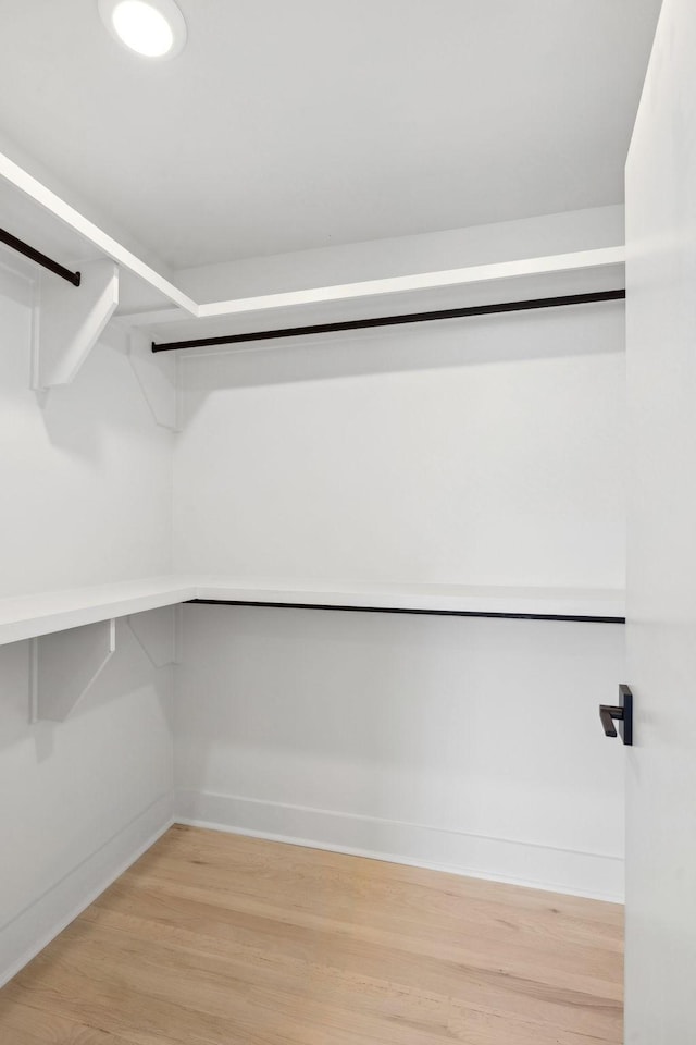 walk in closet with light wood-style floors