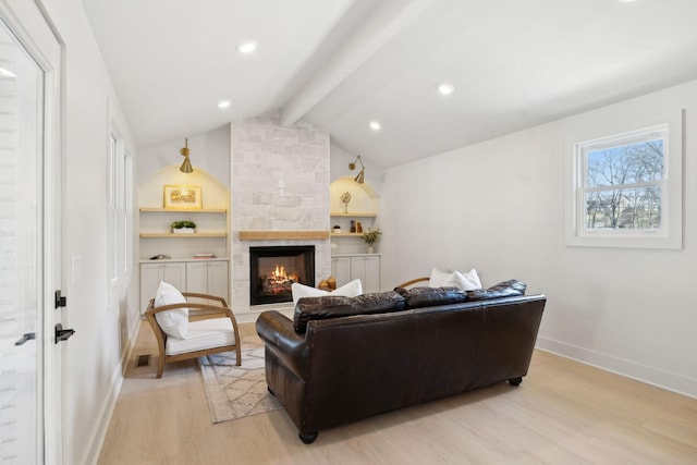 living area featuring vaulted ceiling with beams, baseboards, a fireplace, and light wood finished floors