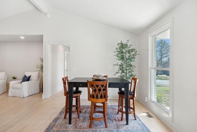 dining area featuring lofted ceiling with beams, light wood-style flooring, and visible vents