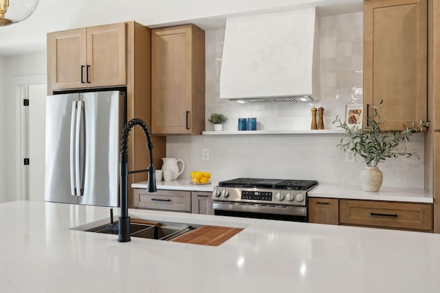 kitchen featuring light countertops, appliances with stainless steel finishes, a sink, and tasteful backsplash