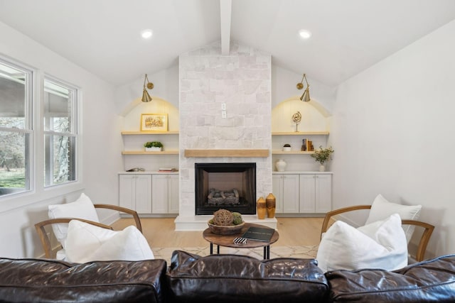 living area with light wood-type flooring, vaulted ceiling with beams, recessed lighting, and a stone fireplace