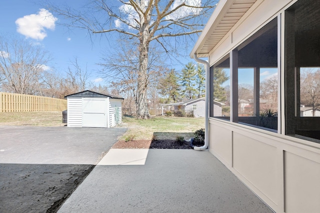 view of yard with an outbuilding, a patio, a shed, and a sunroom