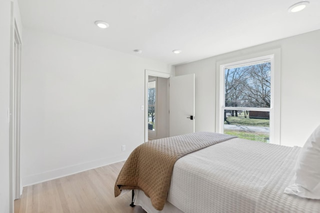 bedroom with light wood-type flooring, baseboards, and recessed lighting