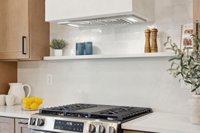 kitchen featuring stainless steel range with gas cooktop, light countertops, and backsplash