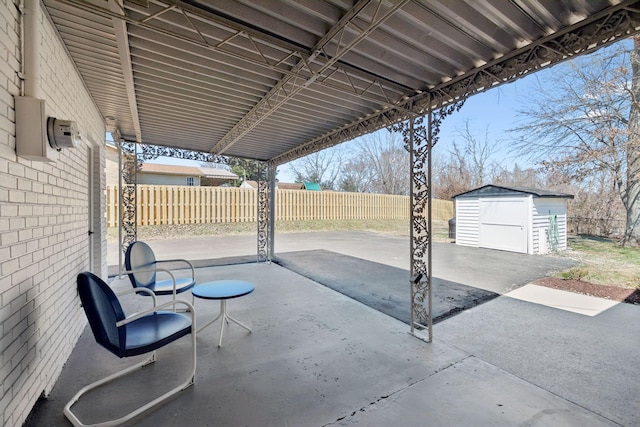 view of patio / terrace featuring an outdoor structure, a shed, and fence